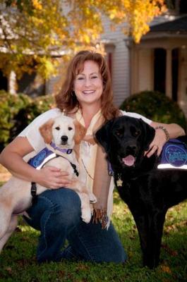 Cheryl Tipton, here with Cezanne (yellow Labrador/Golden Retriever mix) and Padriag (black Labrador), trains service dogs for Blue Ridge Assistance Dogs.